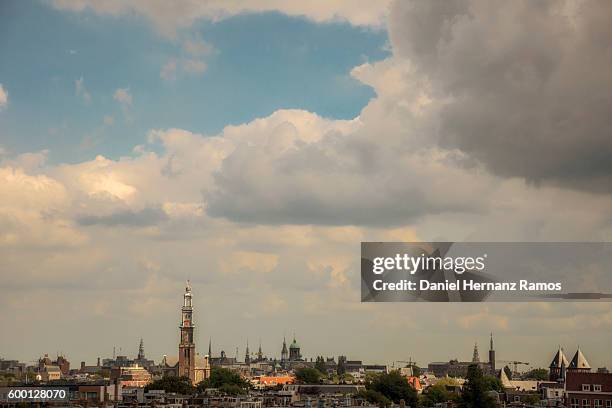 distant view of amsterdam skyline with a church westerkerk in background - skyline amsterdam stock pictures, royalty-free photos & images