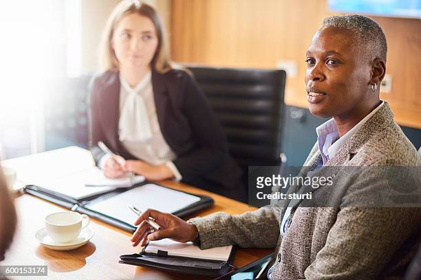 businesswoman listening to colleagues - androgynous professional stock pictures, royalty-free photos & images