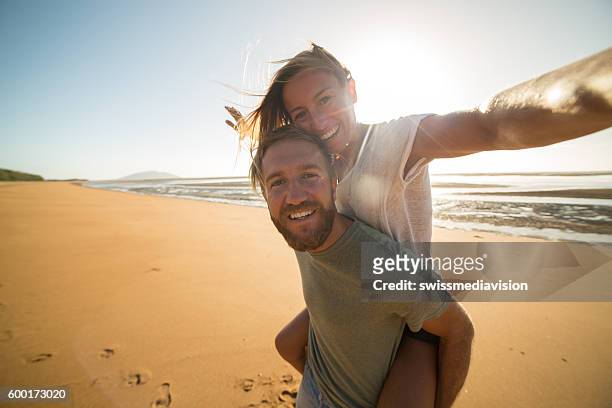 selfie : couple capturing fun moments on the beach - queensland stock pictures, royalty-free photos & images