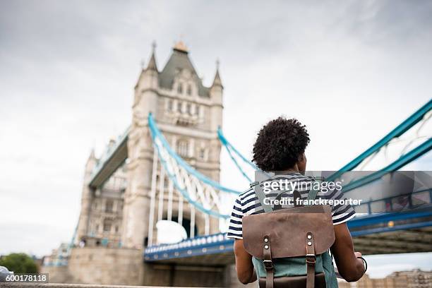 solo traveler in tower bridge area reading a map - london tower bridge stock pictures, royalty-free photos & images