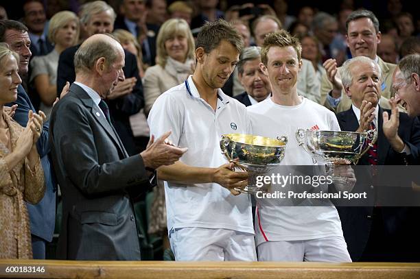 Jonathan Marray of Great Britain and Frederik Nielsen of Denmark hold their winners' trophies after winning their Gentlemans Doubles final match...