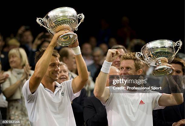 Jonathan Marray of Great Britain and Frederik Nielsen of Denmark lift their winners' trophies after winning their Gentlemans Doubles final match...
