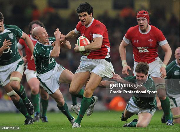 Peter Stringer and Ronan O'Gara of Ireland are brushed aside by the charging Mike Phillips of Wales during the RBS 6 Nations Championship match...