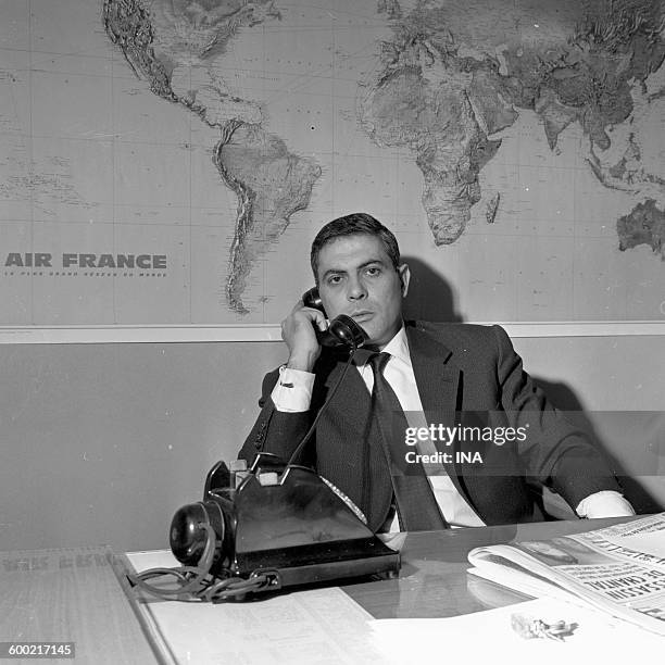 Armand Jammot by the telephone in his office.
