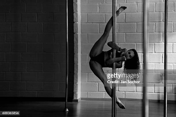 Carolina Echavarria a young Colombian pole dancer grips a pole with her forearms during a pole dance training session at Academia Pin Up on March 02,...