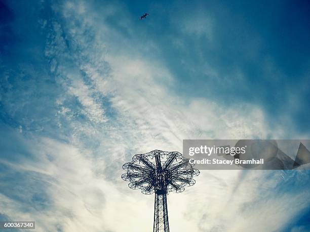 the parachute jump silhouetted against a dramatic sky in coney island, brooklyn - luna park coney island stock-fotos und bilder