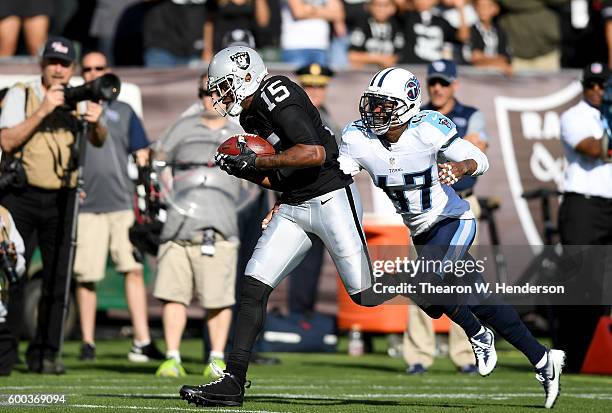 Wide receiver Michael Crabtree of the Oakland Raiders catches a 41 yard pass over defensive back Antwon Blake of the Tennessee Titans in the first...