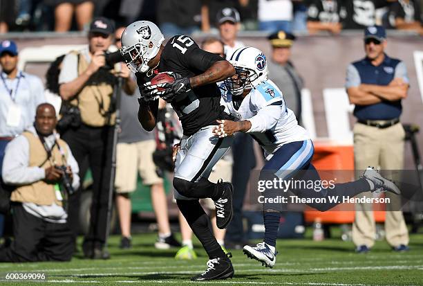 Wide receiver Michael Crabtree of the Oakland Raiders catches a 41 yard pass over defensive back Antwon Blake of the Tennessee Titans in the first...