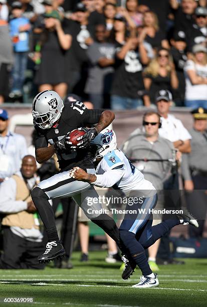 Wide receiver Michael Crabtree of the Oakland Raiders catches a 41 yard pass over defensive back Antwon Blake of the Tennessee Titans in the first...