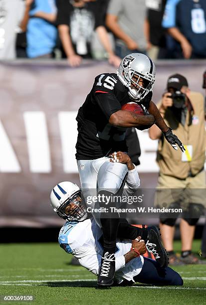 Wide receiver Michael Crabtree of the Oakland Raiders catches a 41 yard pass over defensive back Antwon Blake of the Tennessee Titans in the first...