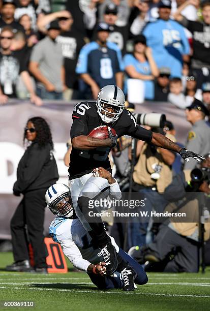 Wide receiver Michael Crabtree of the Oakland Raiders catches a 41 yard pass over defensive back Antwon Blake of the Tennessee Titans in the first...