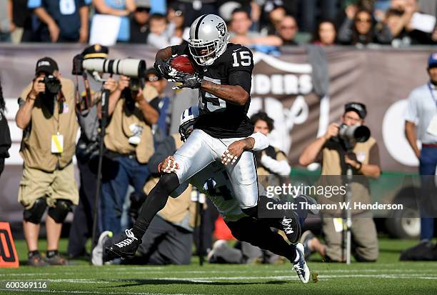 Wide receiver Michael Crabtree of the Oakland Raiders catches a 41 yard pass over defensive back Antwon Blake of the Tennessee Titans in the first...