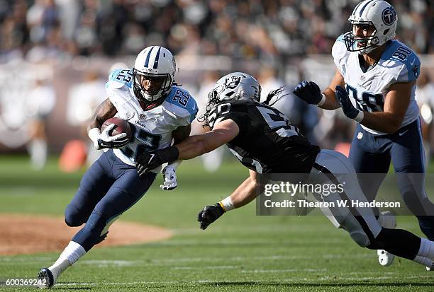 Running back Dexter McCluster of the Tennessee Titans runs throw the arm tackle of outside linebacker Ben Heeney of the Oakland Raiders in the first...