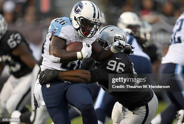 Running back Antonio Andrews of the Tennessee Titans gets tackled by defensive end Denico Autry of the Oakland Raiders in the second half of their...