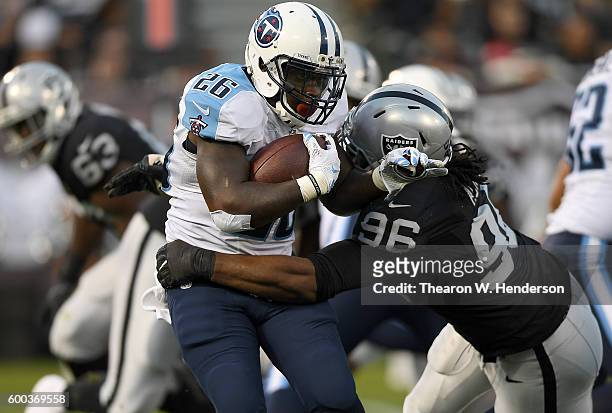 Running back Antonio Andrews of the Tennessee Titans gets tackled by defensive end Denico Autry of the Oakland Raiders in the second half of their...