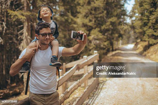 selfie beim naturspaziergang - boy taking picture in forest stock-fotos und bilder