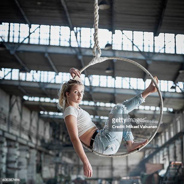 female aerial hoop artist in steel factory - lyra - fotografias e filmes do acervo