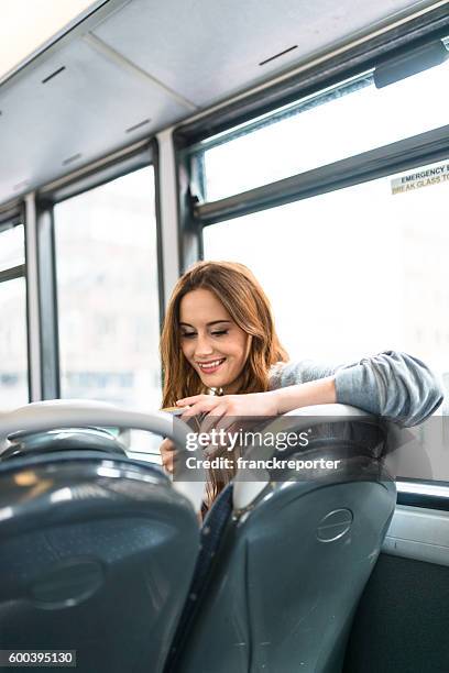 frau in einem bus in london am telefon - bus interior stock-fotos und bilder