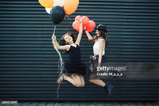 girls dressed for halloween jumping with balloon - helium stock pictures, royalty-free photos & images