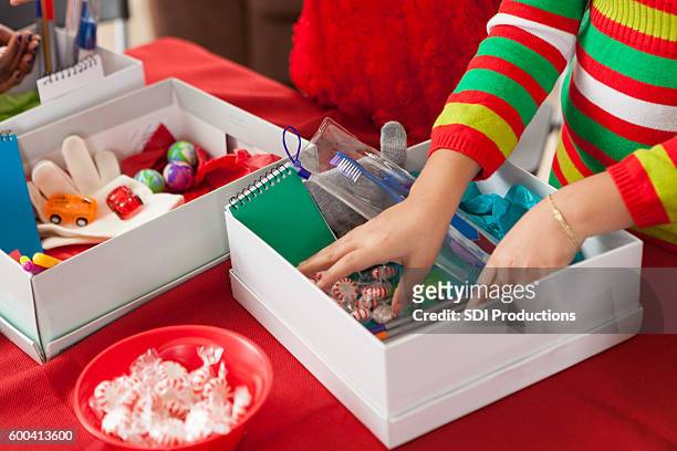female children filling holiday donation boxes for children in need - shoe boxes stock pictures, royalty-free photos & images