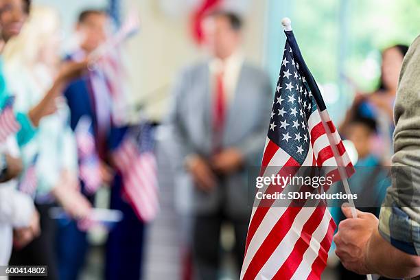 anhänger schwenken amerikanische flaggen bei wahlkampfpolitischer kundgebung - kandidaat stock-fotos und bilder