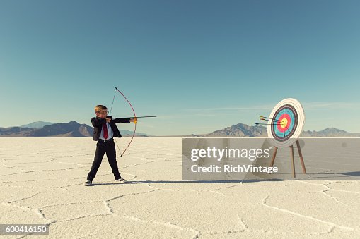 Young Boy Businessman Shoots Arrows at Target Young Boy Businessman Shoots Arrows at Target