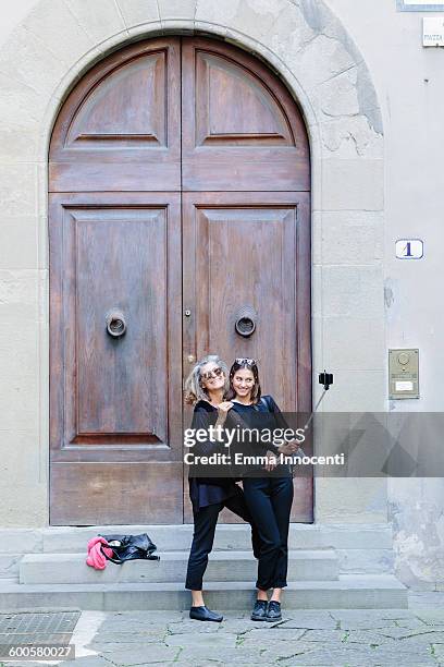 mum and daughter taking photo with selfie stick - selfiestick stock-fotos und bilder