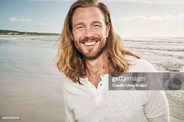 caucasian man smiling on beach - long hair man stock pictures, royalty-free photos & images