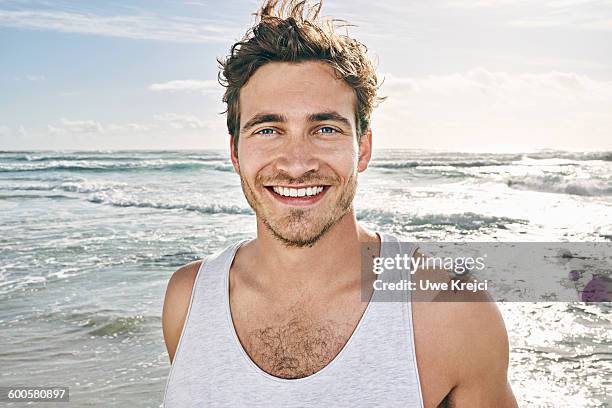 caucasian man smiling on beach - young man blue eyes stock pictures, royalty-free photos & images