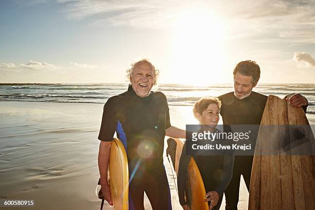 three generations of surfers on beach - hispanic man on beach stock-fotos und bilder
