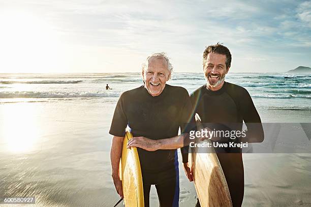 surfer on beach - senior adult stock-fotos und bilder