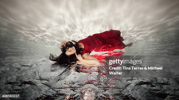 woman underwater. in a red dress. - tina terras michael walter stock pictures, royalty-free photos & images