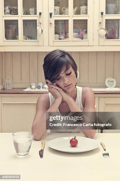 young woman with tomato on a plate - küchenbuffet stock-fotos und bilder