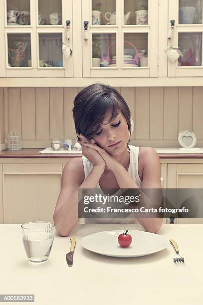young woman with tomato on a plate - anorexie nerveuse photos et images de collection