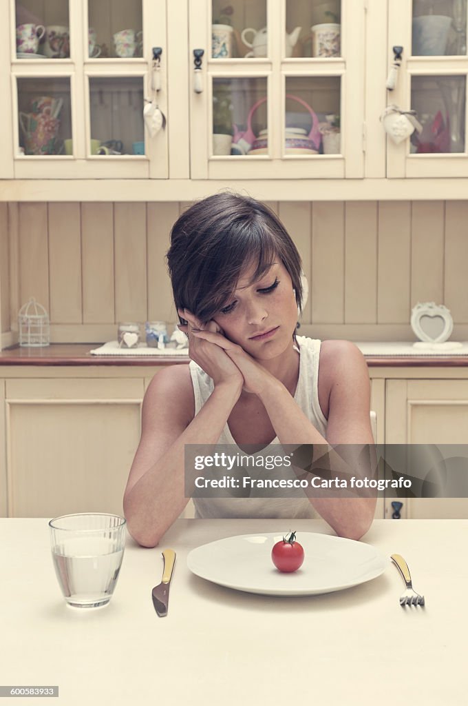 Young woman with tomato on a plate