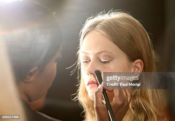 Stylist works on a model's makeup backstage during the Noon By Noor fashion show during New York Fashion Week: The Shows September 2016 at The...