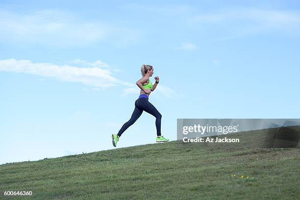 woman running in the park - uphill stockfoto's en -beelden