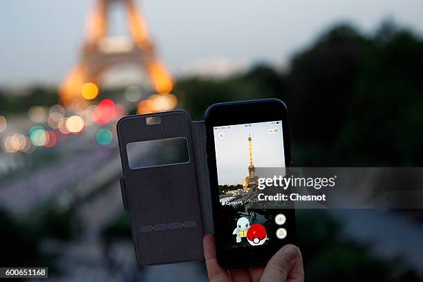 Tourist plays Nintendo Co.'s Pokemon Go augmented-reality game at the Trocadero in front of the Eiffel tower on September 8, 2016 in Paris, France....