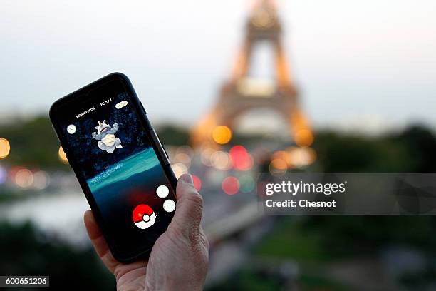 Tourist plays Nintendo Co.'s Pokemon Go augmented-reality game at the Trocadero in front of the Eiffel tower on September 8, 2016 in Paris, France....
