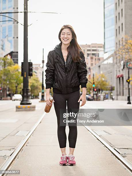 young woman on commuter tracks in city street - leggings stock pictures, royalty-free photos & images