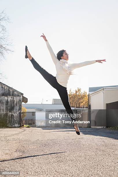 young dancer leaping in back lot - long sleeved fotografías e imágenes de stock