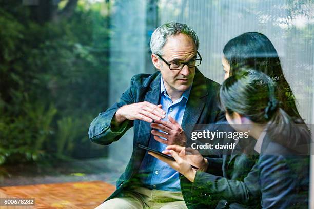 uomo d'affari inglese che lavora consulenza alle donne d'affari professionali aziendali giapponesi - japanese culture foto e immagini stock