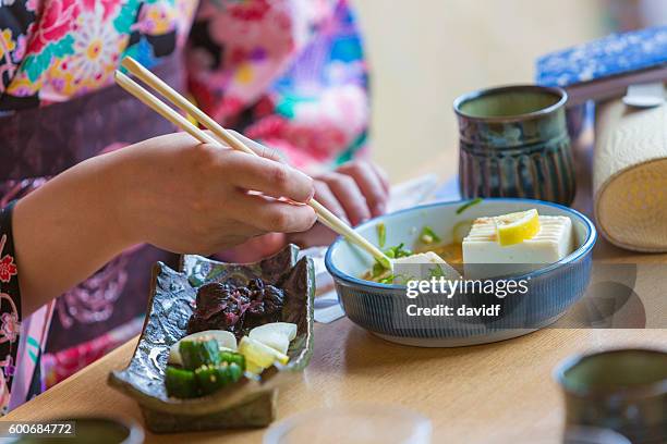 kimono wearing young japanese women eating noodles in a restaurant - geisha eating stockfoto's en -beelden