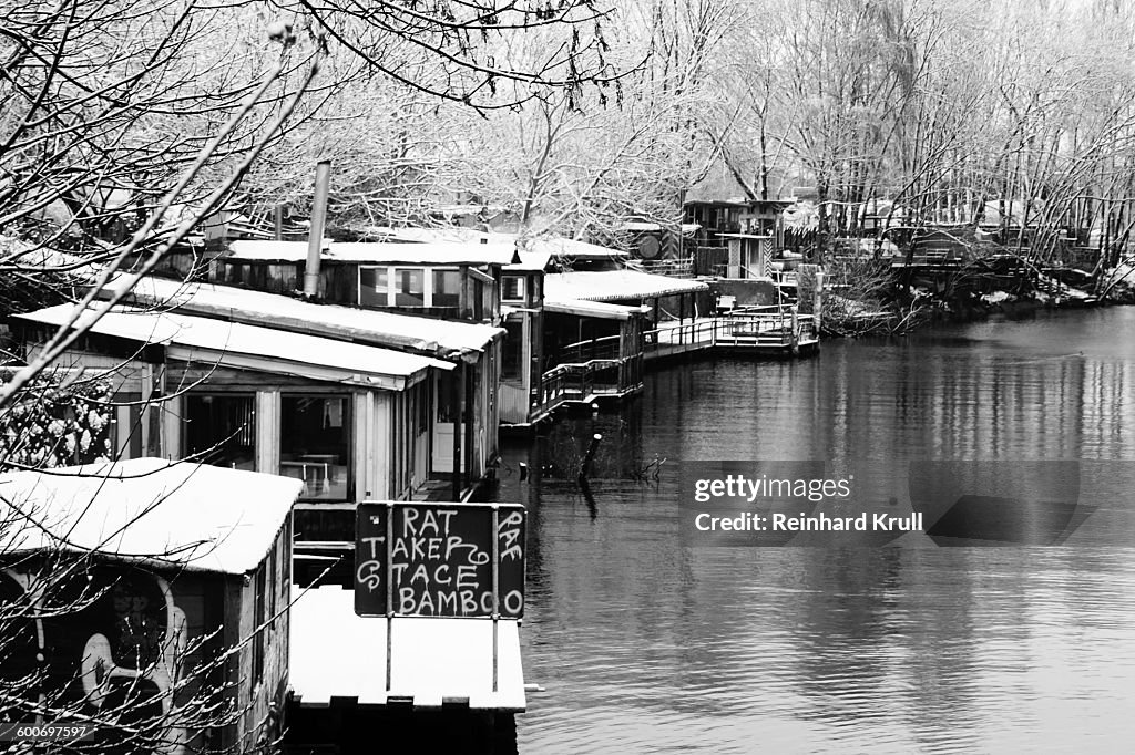 Stilt Houses In River Against Bare Trees During Winter