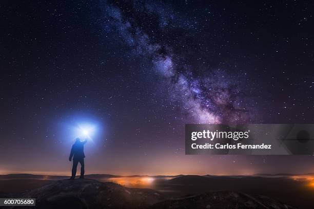 man looking up the milky way - lampe de poche photos et images de collection