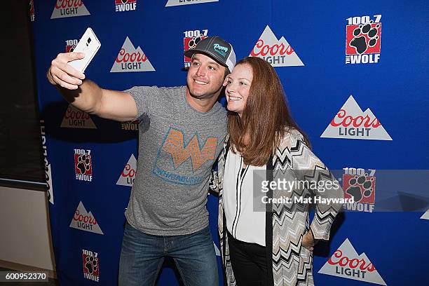Country Music Singer Easton Corbin poses for a selfie with a fan after performing an acoustic set hosted by 100.7 The Wolf on September 8, 2016 in...