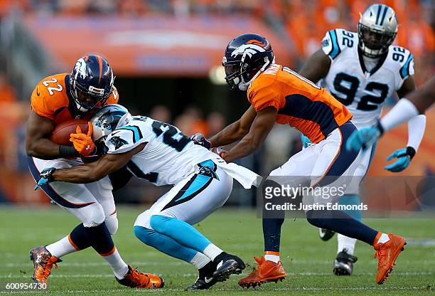 Running back C.J. Anderson of the Denver Broncos is hit by defensive back Robert McClain of the Carolina Panthers in the first half at Sports...