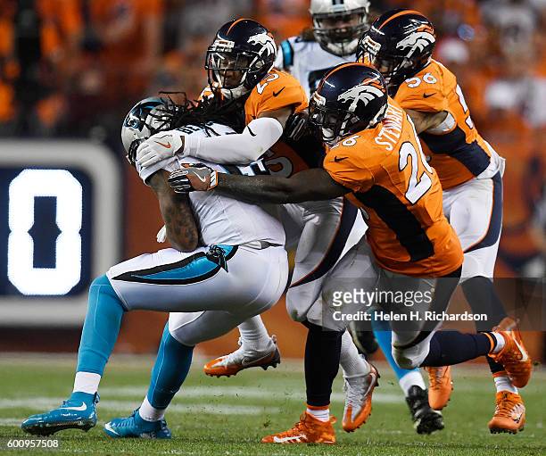 Wide receiver Kelvin Benjamin of the Carolina Panthers is gang tackled by linebacker Shane Ray of the Denver Broncos, Chris Harris and Darian Stewart...