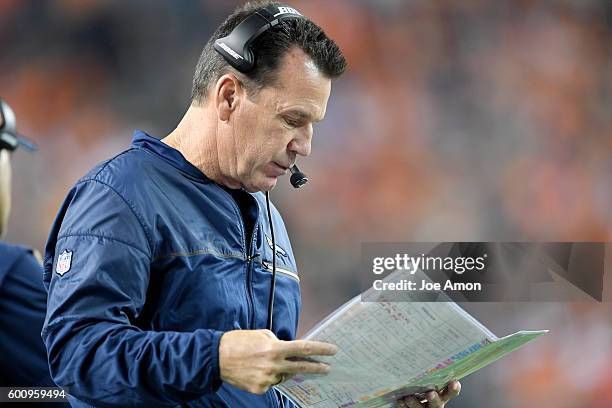 Head coach Gary Kubiak of the Denver Broncos reads the playbook against the Carolina Panthers during the third quarter. The Denver Broncos hosted the...