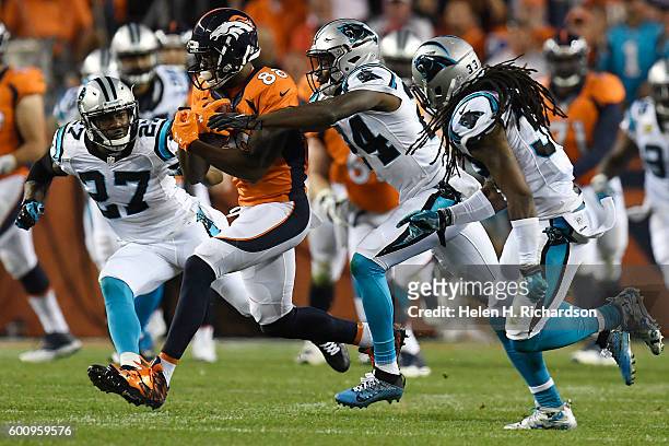 Wide receiver Demaryius Thomas of the Denver Broncos is tackled by cornerback James Bradberry of the Carolina Panthers as Robert McClain and Tre...